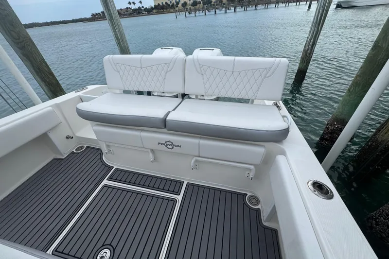 Yacht Photos Pics 2018 Fountain 34 Center Console boat with white seating and gray deck, docked by water.