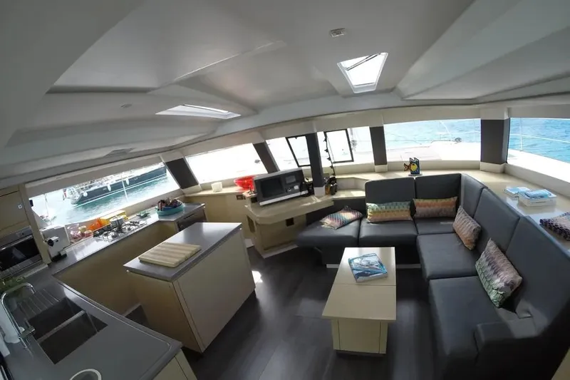 Xclip Yacht Photos Pics Luxurious interior of 2015 Fountaine Pajot SABA 50 catamaran with modern kitchen and seating area.