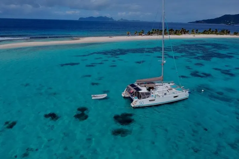 Xclip Yacht Photos Pics Fountaine Pajot SABA 50 catamaran anchored in turquoise waters near a tropical island, 2015 model.