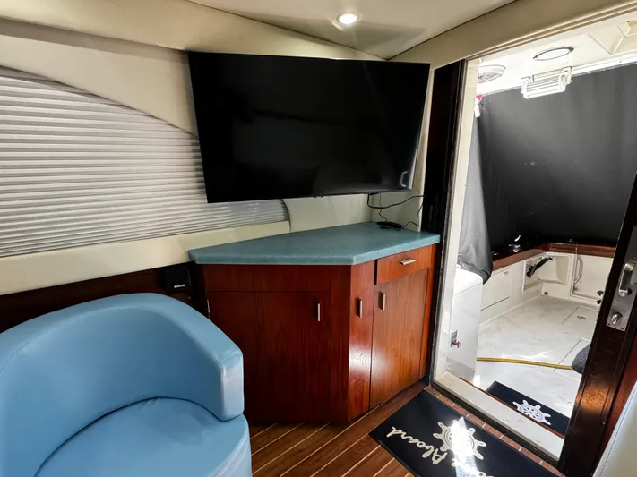 Sweet Melissa Yacht Photos Pics Interior of 1992 Ocean Yachts 48 Convertible with TV, blue chair, and wooden cabinetry.
