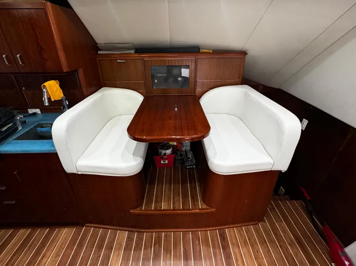 Sweet Melissa Yacht Photos Pics Interior of 1992 Ocean Yachts 48 Convertible with wooden dining area and white seating.