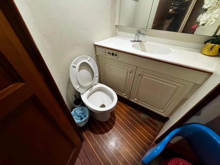 Sweet Melissa Yacht Photos Pics Bathroom interior of 1992 Ocean Yachts 48 Convertible with wooden flooring and white fixtures.