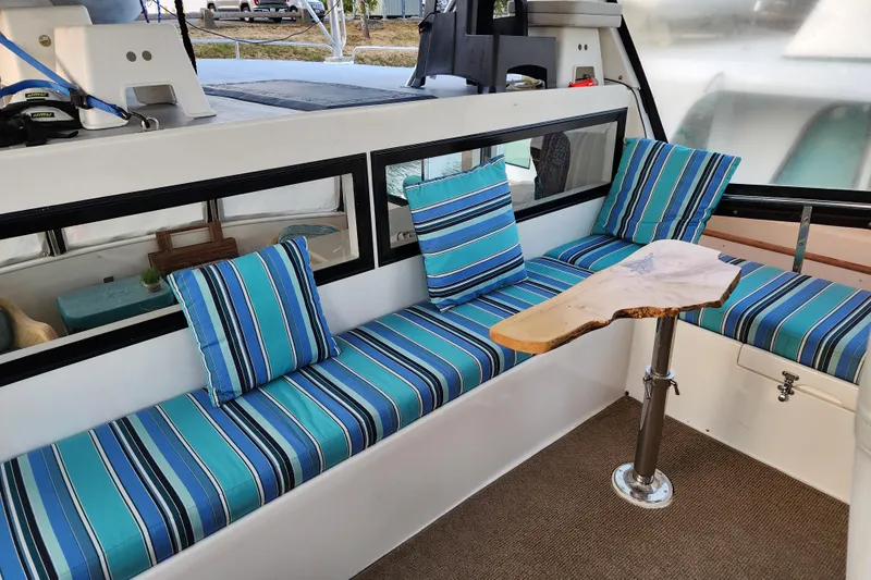  Yacht Photos Pics Cozy seating area on 2000 Novatec Cockpit Motor Yacht with striped cushions and wooden table.