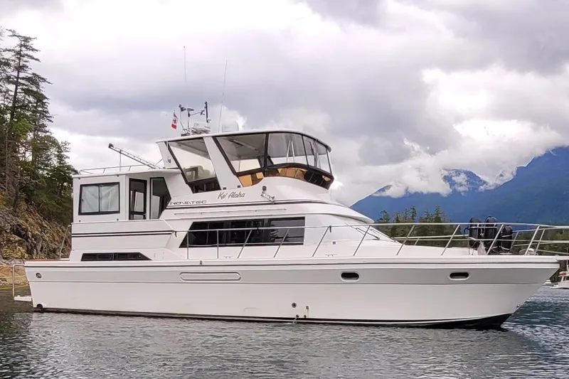  Yacht Photos Pics 2000 Novatec Cockpit Motor Yacht on scenic water with mountainous backdrop.