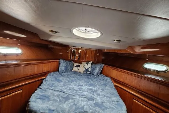  Yacht Photos Pics Cozy cabin interior of 2000 Novatec Cockpit Motor Yacht with blue bedding and wood paneling.