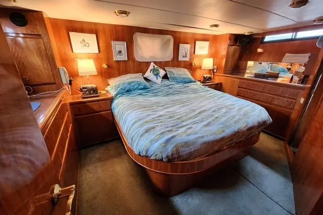  Yacht Photos Pics Luxurious bedroom in 2000 Novatec Cockpit Motor Yacht with wood paneling and cozy lighting.