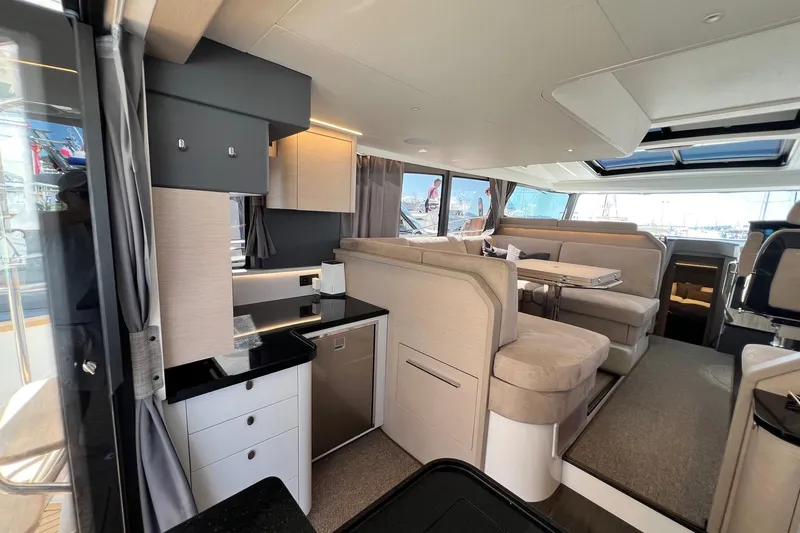  Yacht Photos Pics Luxurious interior of 2025 Nimbus 495 Flybridge yacht with modern seating and kitchenette.
