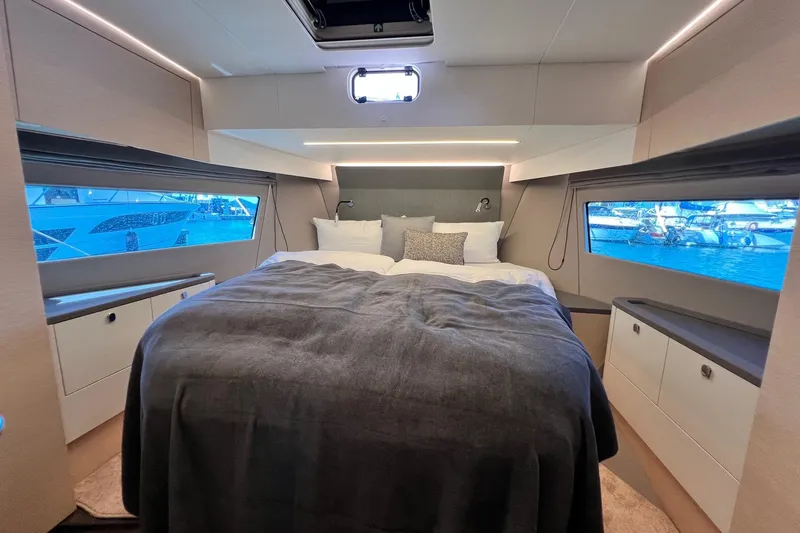  Yacht Photos Pics Luxurious bedroom interior of 2025 Nimbus 495 Flybridge yacht with panoramic windows.