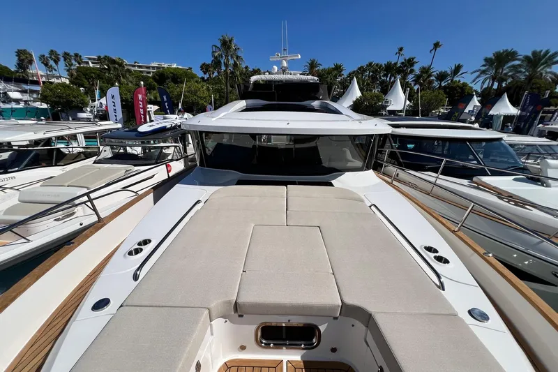  Yacht Photos Pics 2025 Nimbus 495 Flybridge yacht with spacious deck, docked among other boats.
