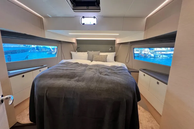  Yacht Photos Pics Luxurious bedroom interior of 2025 Nimbus 495 Flybridge yacht with panoramic windows.