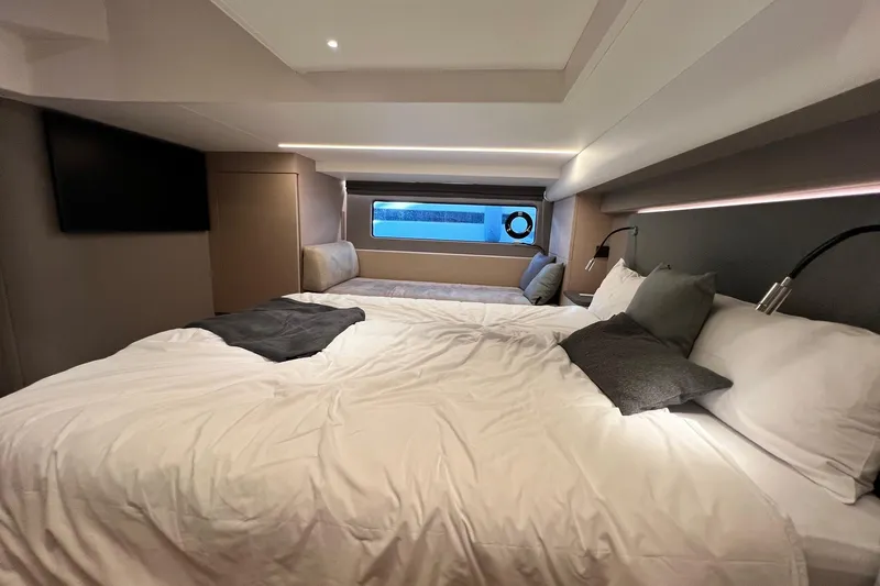  Yacht Photos Pics Luxurious bedroom interior of 2025 Nimbus 495 Flybridge yacht with modern design and cozy bedding.