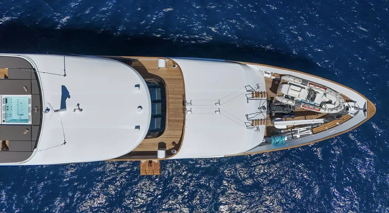 Magna Grecia Yacht Photos Pics Aerial view of a 1986 Custom Elsflether Werft yacht on blue ocean water.