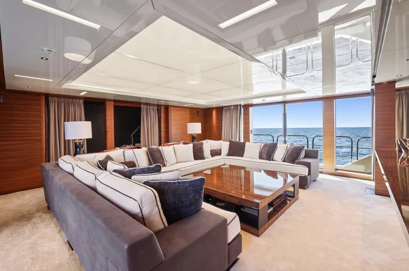 Magna Grecia Yacht Photos Pics Luxurious yacht interior with large sectional sofa, wooden accents, and ocean view, Elsflether Werft 1986.