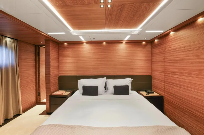 Magna Grecia Yacht Photos Pics Luxurious yacht bedroom with wood paneling, modern lighting, and elegant bedding, Elsflether Werft 1986.