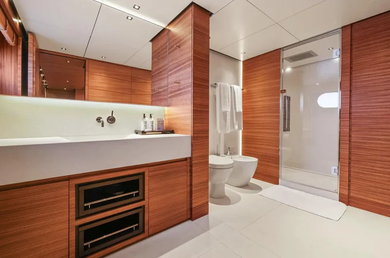 Magna Grecia Yacht Photos Pics Luxurious yacht bathroom with modern wood paneling, sleek fixtures, and spacious shower.