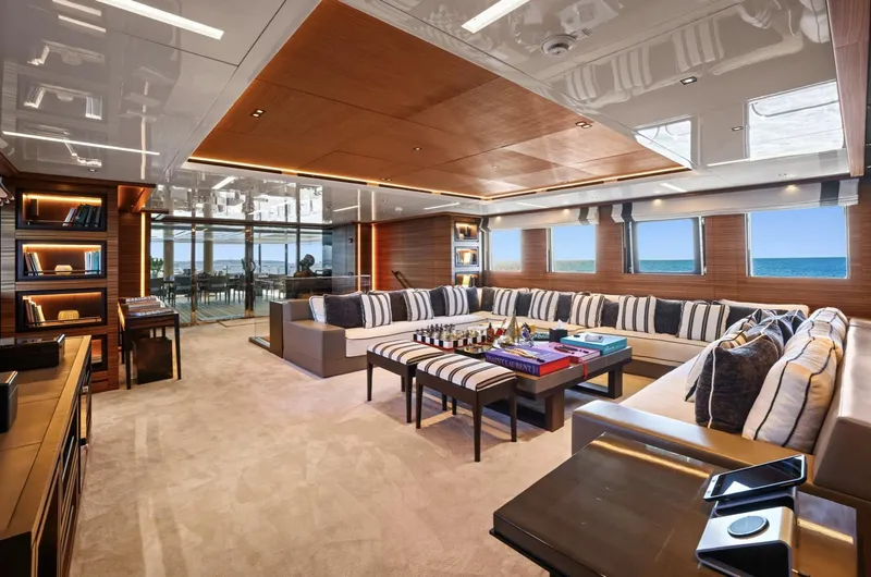 Magna Grecia Yacht Photos Pics Luxurious yacht interior with striped seating, ocean view, and elegant decor, Custom Elsflether Werft 1986.