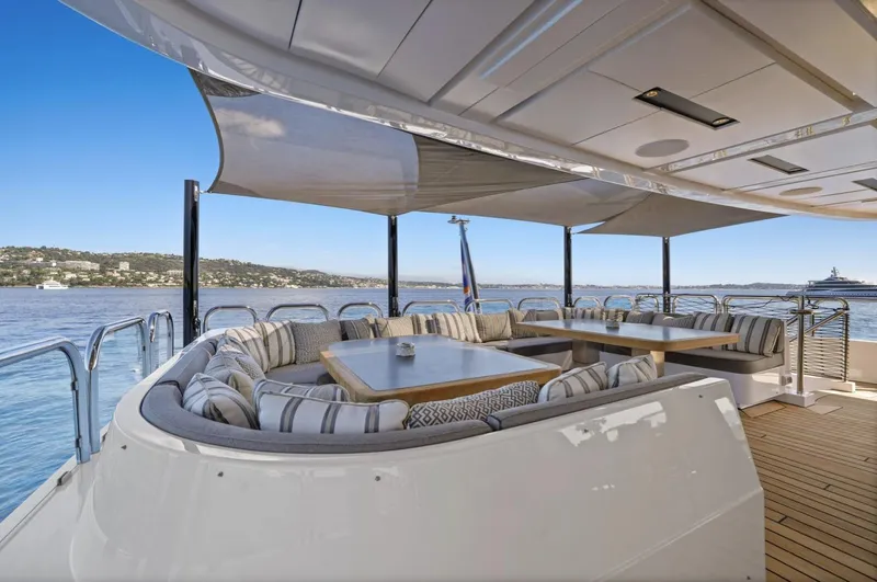 Magna Grecia Yacht Photos Pics Luxurious yacht deck with elegant seating, custom Elsflether Werft 1986, overlooking serene waters.