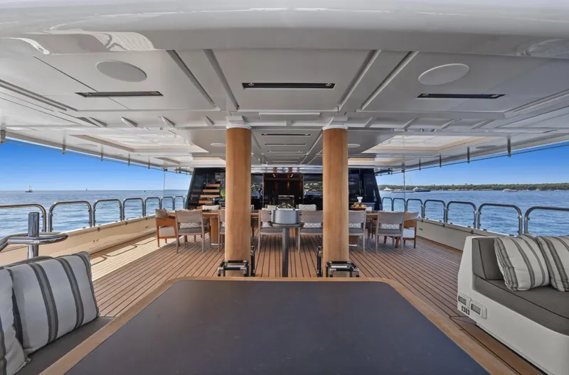 Magna Grecia Yacht Photos Pics Luxurious yacht deck with seating, dining area, and ocean view, Custom Elsflether Werft 1986 model.