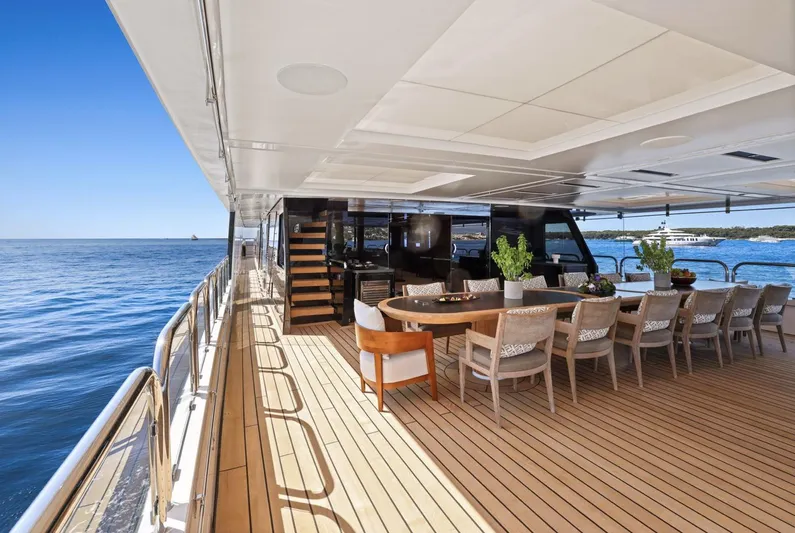 Magna Grecia Yacht Photos Pics Luxurious yacht deck with dining area, Custom Elsflether Werft, 1986, overlooking serene ocean view.