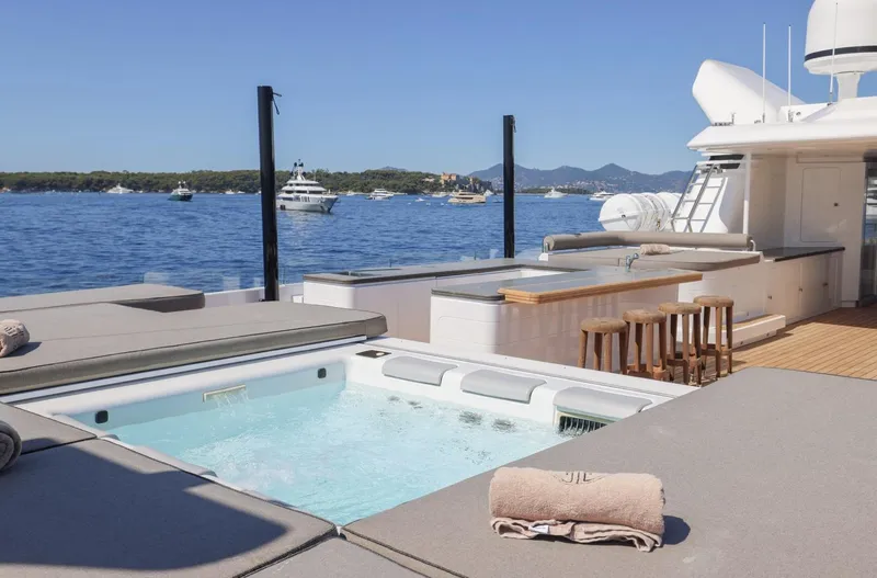 Magna Grecia Yacht Photos Pics Luxurious yacht deck with hot tub, bar stools, and ocean view, Elsflether Werft 1986 model.