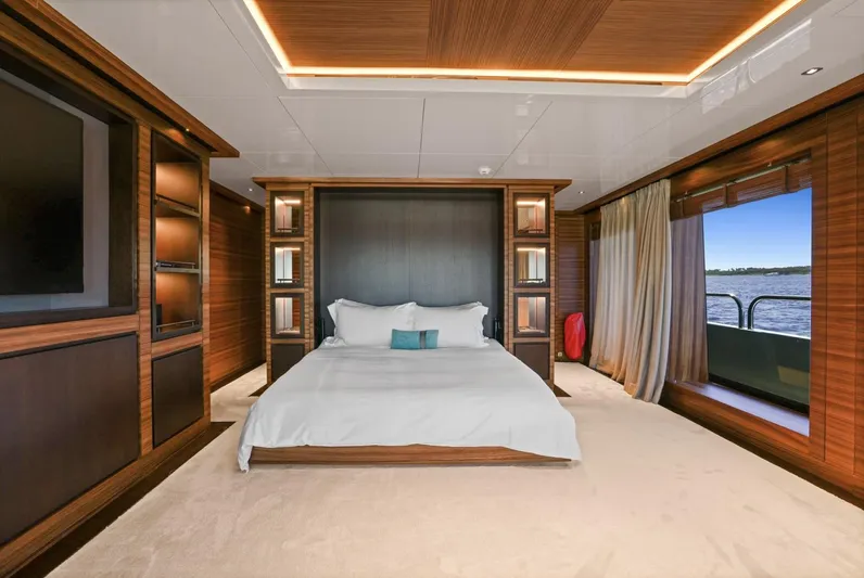 Magna Grecia Yacht Photos Pics Luxurious yacht bedroom with wood paneling, large bed, and ocean view. Custom Elsflether Werft, 1986.