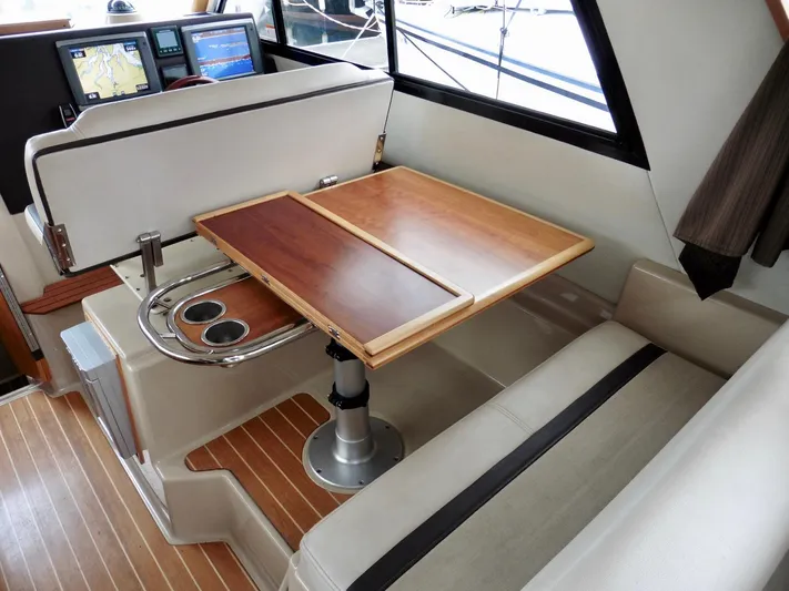  Yacht Photos Pics 2015 Cutwater 30CB interior with wood table, seating, and navigation screens.