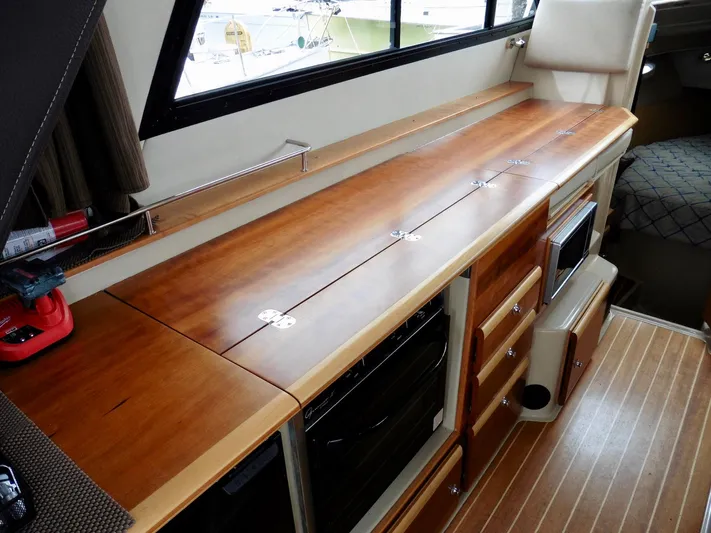  Yacht Photos Pics 2015 Cutwater 30CB interior with wooden cabinetry and modern appliances.