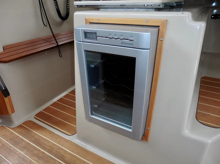  Yacht Photos Pics 2015 Cutwater 30CB interior with built-in Dometic fridge and wood accents.