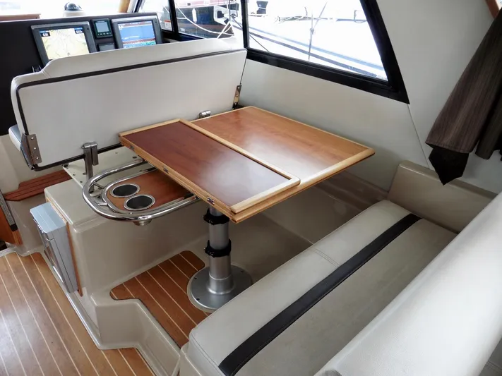  Yacht Photos Pics Interior of 2015 Cutwater 30CB boat with foldable wooden table and seating area.