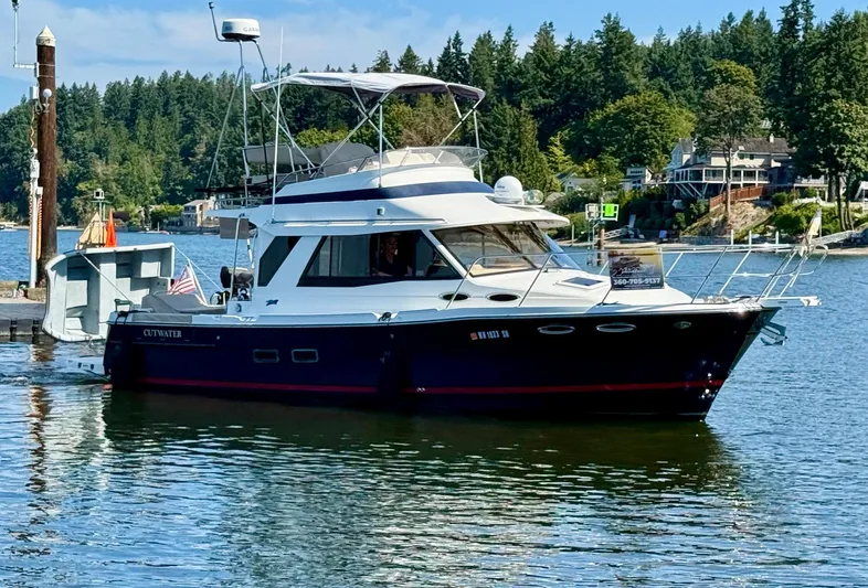  Yacht Photos Pics 2015 Cutwater 30CB boat docked on a scenic lake with lush greenery.