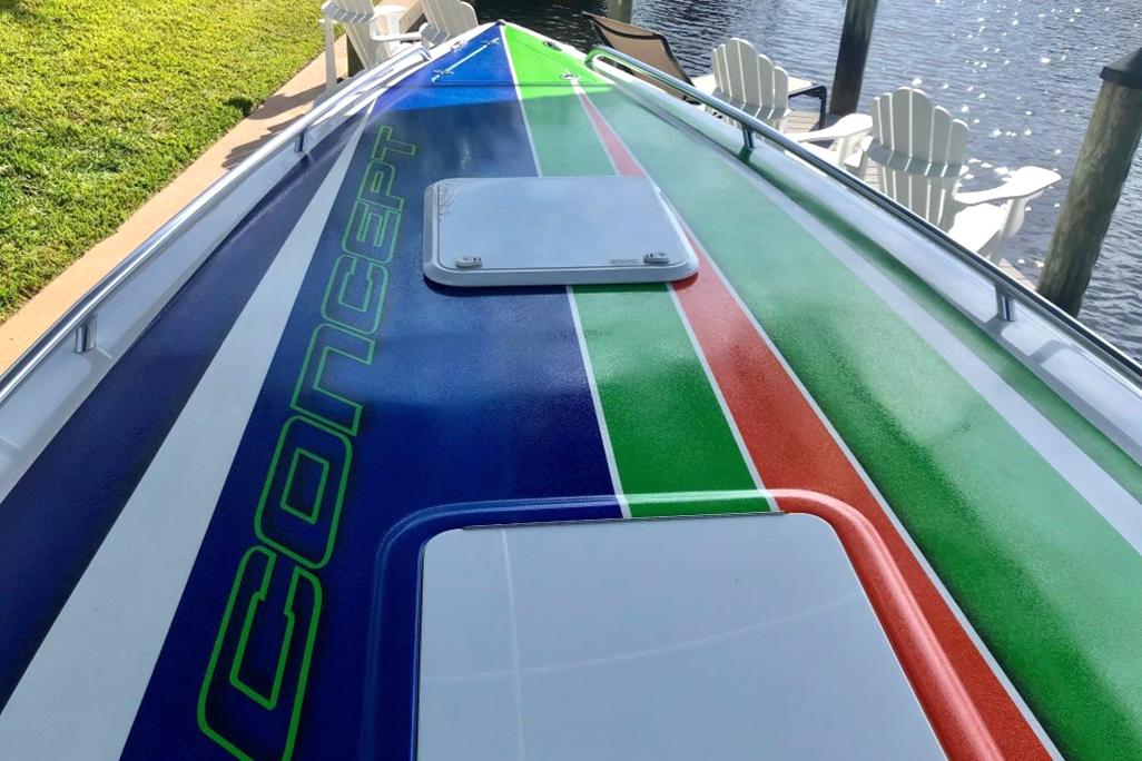 2020 Concept 36' Cuddy Cabin boat with colorful deck design docked by the water.