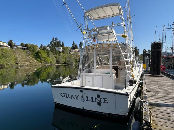  Yacht Photos Pics 1999 Carolina Classic 35 boat docked, clear sky, calm water, trees in background.