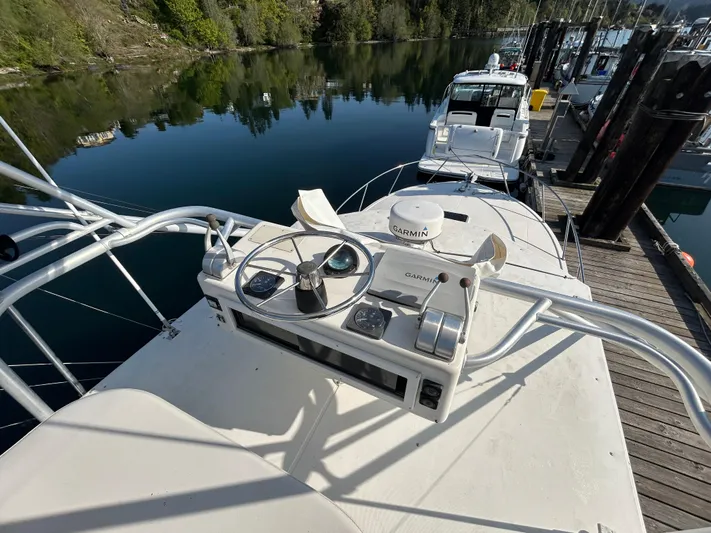  Yacht Photos Pics 1999 Carolina Classic 35 boat helm with Garmin equipment, docked by calm waters.