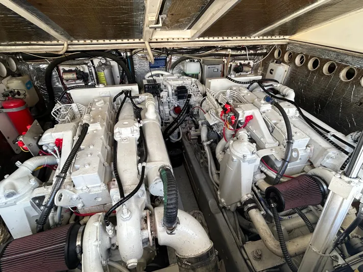  Yacht Photos Pics Engine room of a 1999 Carolina Classic 35 boat, showcasing dual engines and mechanical components.