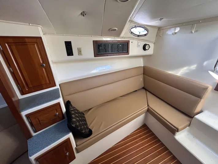  Yacht Photos Pics 1999 Carolina Classic 35 interior with beige seating, wooden cabinets, and striped flooring.