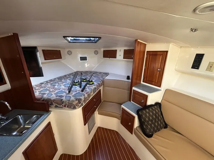  Yacht Photos Pics 1999 Carolina Classic 35 boat interior with cozy seating, bed, and wooden cabinetry.