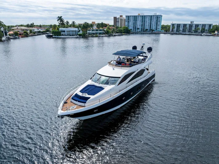 Persistence Yacht Photos Pics 2006 Sunseeker 75 Yacht cruising on a calm waterway with scenic city backdrop.