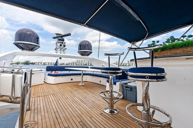 Persistence Yacht Photos Pics Luxurious 2006 Sunseeker 75 Yacht deck with seating and bar stools under canopy.