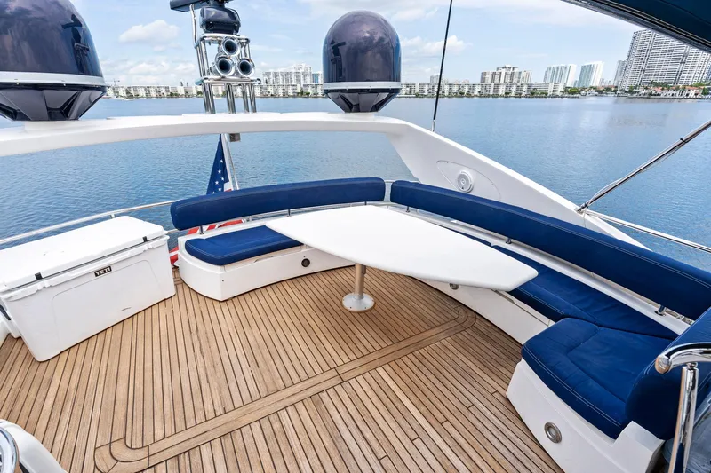 Persistence Yacht Photos Pics Luxurious 2006 Sunseeker 75 Yacht deck with blue seating and scenic waterfront view.