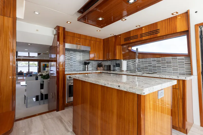 Ritz Sea Yacht Photos Pics Luxurious kitchen interior of 2014 Hatteras 80 Motor Yacht Sky Lounge with wood cabinetry.