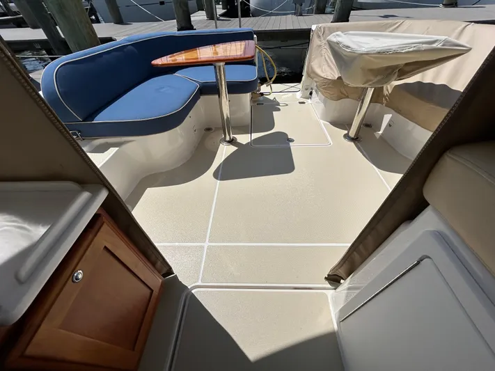 Islander Yacht Photos Pics 2018 Back Cove 32 boat interior with blue seating and wooden table.
