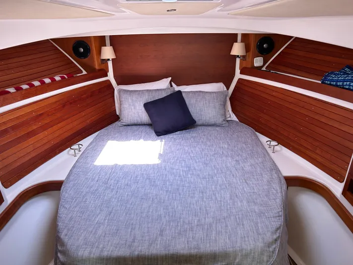 Islander Yacht Photos Pics Cozy cabin interior of 2018 Back Cove 32 with wooden accents and comfortable bedding.