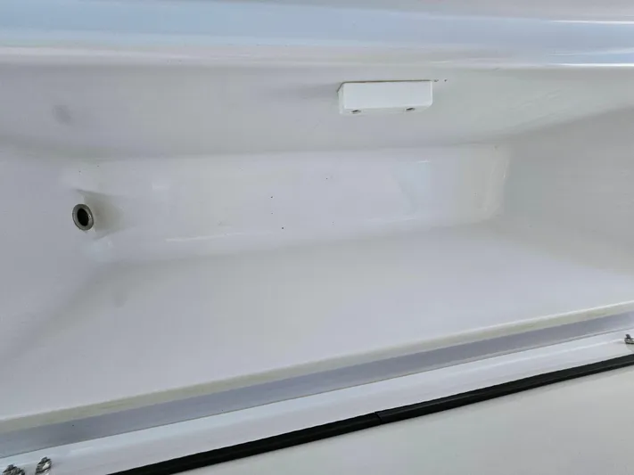  Yacht Photos Pics 2022 Century 2900 Center Console storage compartment, white interior, close-up view.