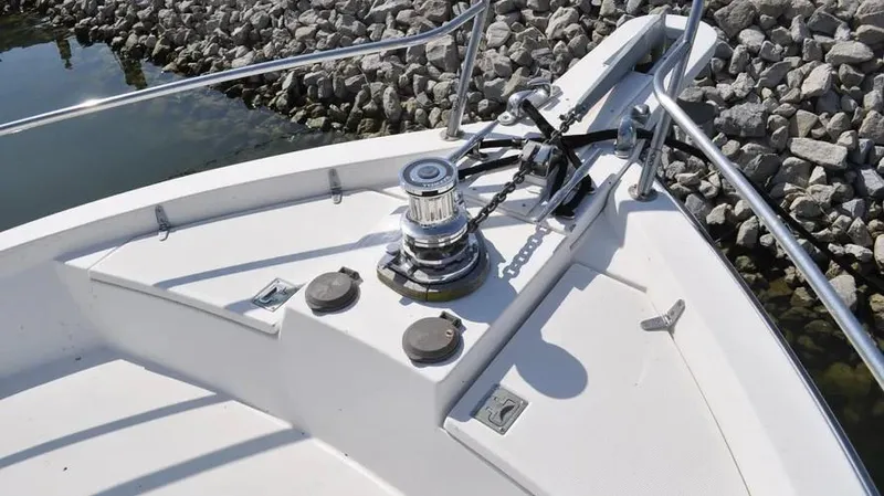 Raindance Yacht Photos Pics Bow of 1998 Sabre 36 Fast Trawler with winch and railings, docked by rocky shore.