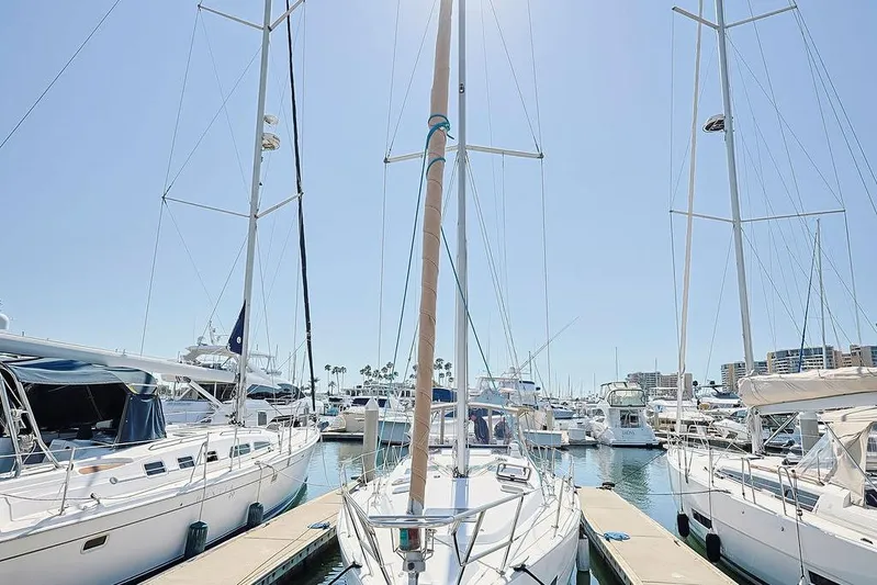 Mustang III Yacht Photos Pics 2007 Beneteau Oceanis 423 sailboat docked in a sunny marina, surrounded by other boats.