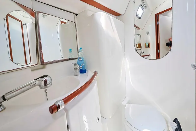 Mustang III Yacht Photos Pics Bathroom interior of 2007 Beneteau Oceanis 423 yacht, featuring sink, mirror, and toilet.