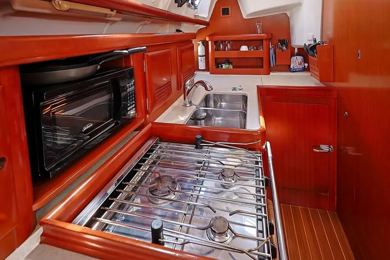 Mustang III Yacht Photos Pics Galley kitchen in 2007 Beneteau Oceanis 423 yacht with stove, microwave, and sink.