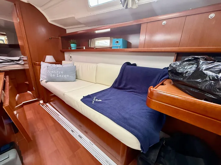  Yacht Photos Pics Interior of 2012 Beneteau Oceanis 37 sailboat with cozy seating and wooden cabinetry.