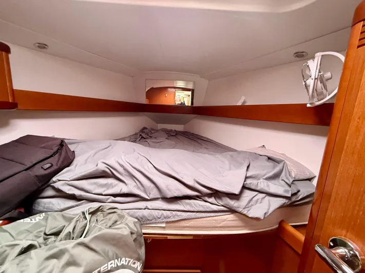  Yacht Photos Pics Cozy cabin interior of 2012 Beneteau Oceanis 37 sailboat with bed and wooden accents.