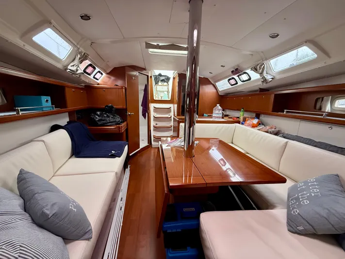  Yacht Photos Pics Interior of 2012 Beneteau Oceanis 37 sailboat with cozy seating and wooden table.